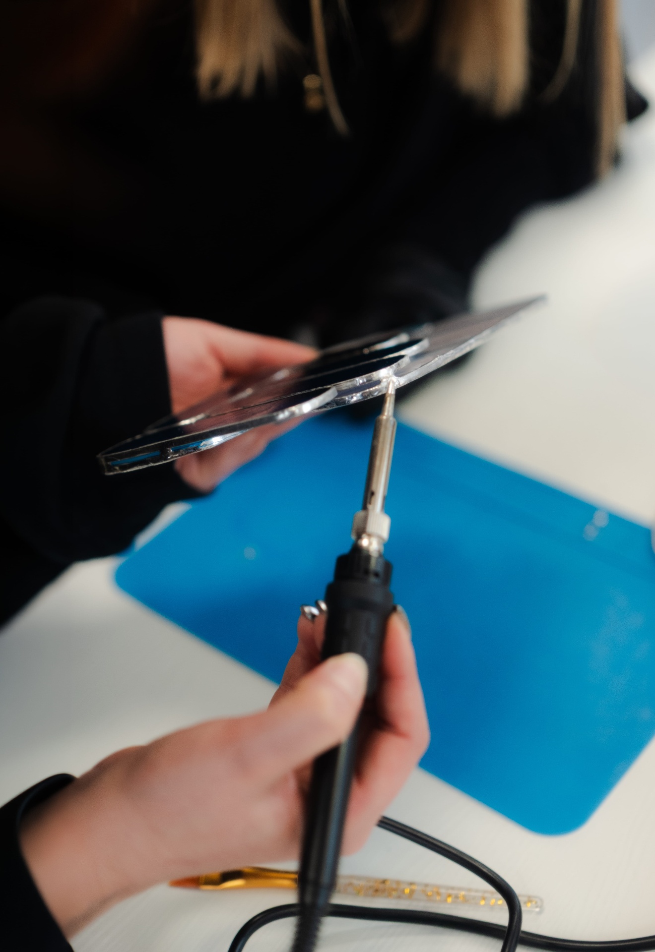 Soudure d'un suncatcher rond en vitrail sur fond bleu
